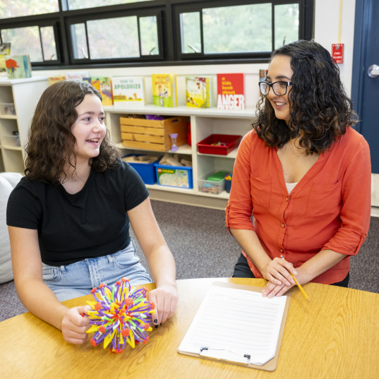 A school psychologist interacts with a student.