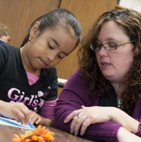 A teacher candidate works with a student during her practicum experience.