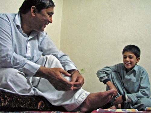 Zaher Wahab, relaxing at home in Kabul with his nephew's son. Here, Wahab is encouraging the boy to take his schoolwork more seriously.